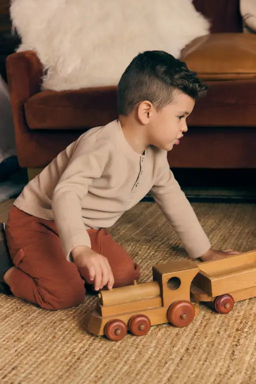 Toddler Boy card showing Toddler Playing with Trains on the floor