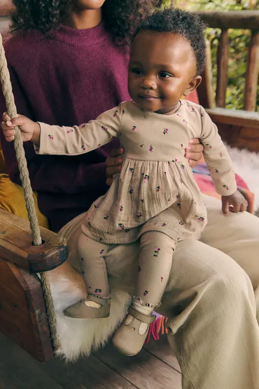 baby sitting on mothers lap