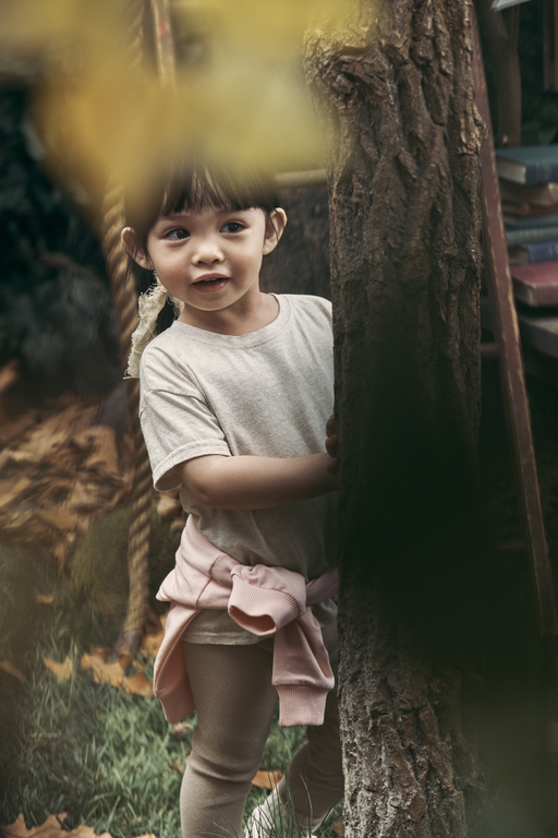 Boy hiding behind tree