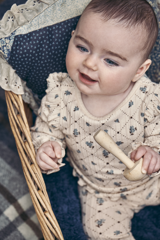 Baby holding wooden mushroom