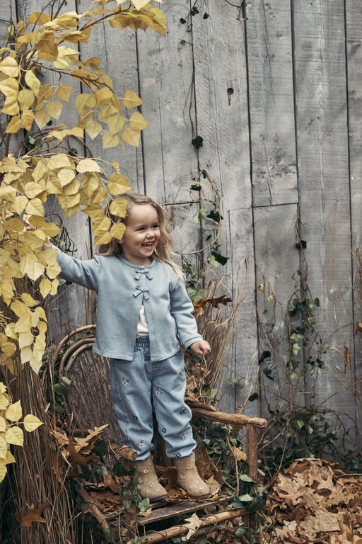 Toddler standing next to fence