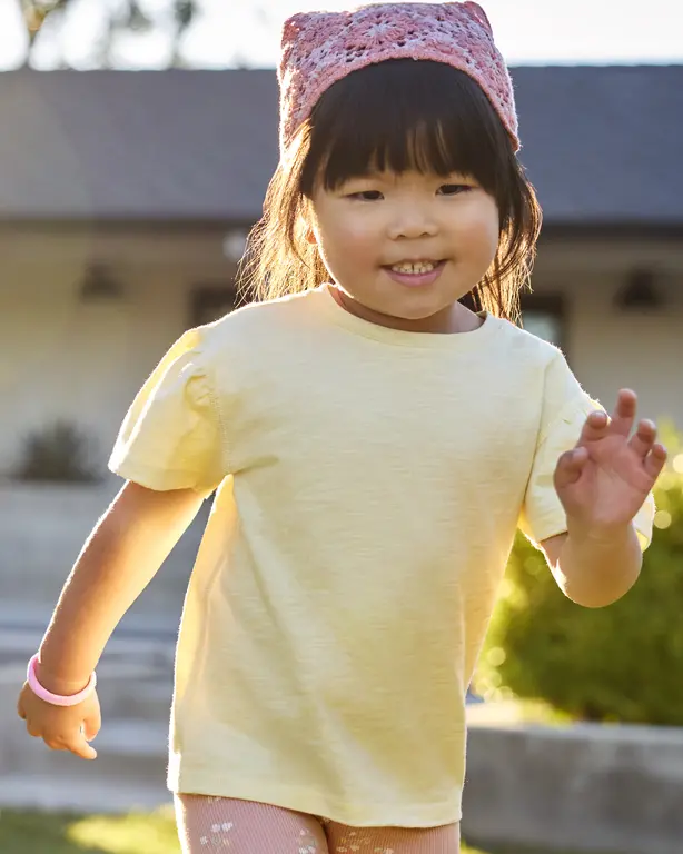 Girl smiling and waving at the camera